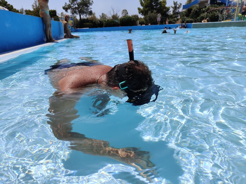 Nuotatore con snorkeling in piscina